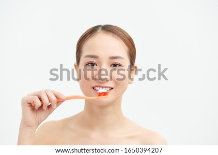 attractive asian woman brushing teeth on white background