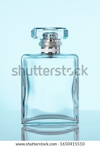 Perfume glass bottle. Clear parfum glass bottle with spray atomizer. Blue background. Copy space and mockup. Vertical orientation.