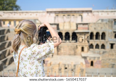 Young woman capture photo of India Stepwell in the village of Abhaneri, Rajasthan, India