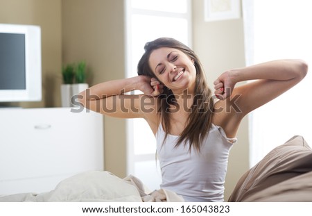 A lovely young woman stretching in the morning  Royalty-Free Stock Photo #165043823