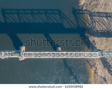 Aerial drone view. Railway bridge over the Dnieper River in Kiev. The shadow of the bridge falls on the smooth surface of the river.