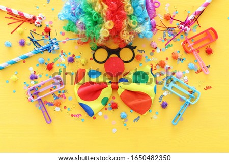 carnival, party and Purim celebration concept (jewish carnival holiday) over yellow background