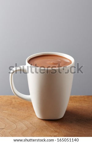 White cup of hot chocolate on wooden table