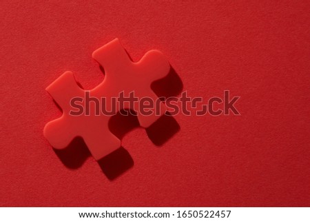 top view of red jigsaw puzzle on red background,