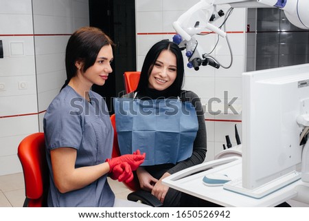 The dentist shows a picture of the patient's teeth and tells the necessary treatment. Dentistry, health.
