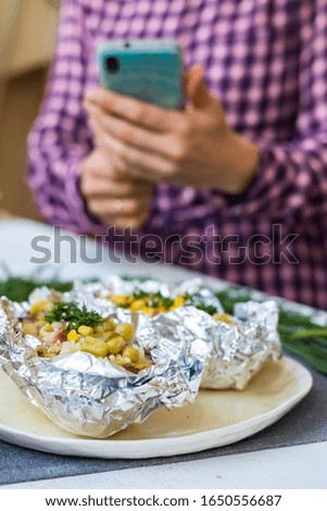 Woman take picture of vegan lunch with phone in the kitchen on table. Healthy diet food. Lifestyle and sunny style.