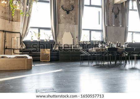 dark design of huge studio apartment in loft style with big windows and black wooden contemporary furniture with free planing. 