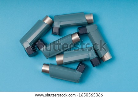 Set of asthma inhalers on blue background 