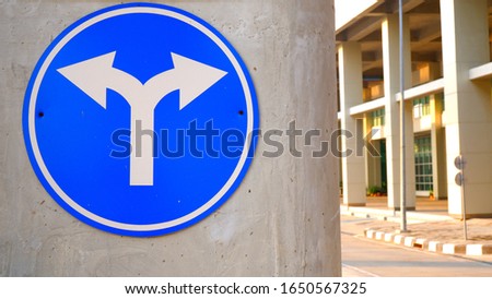Traffic sign of arrow to left and right on concrete pole