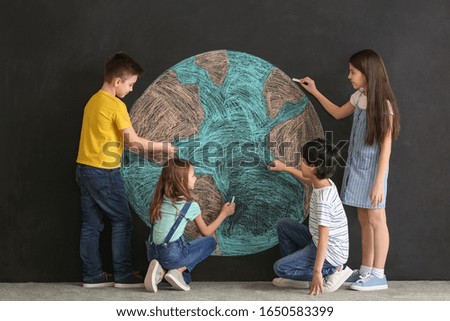 Little children drawing planet on dark background. Earth Day celebration