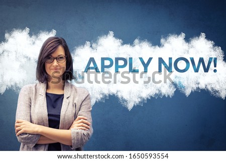 Apply now! Confident businesswoman with arms crossed standing next to sign on the wall. Job search concept.