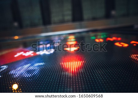 Display of Stock market quotes with city lights reflect on glass