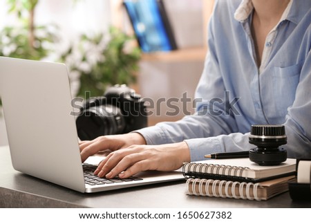 Journalist working with laptop at table, closeup