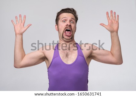 Caucasian sportive man with mustache showign 10 ten fingers. Counting gesture studio shot