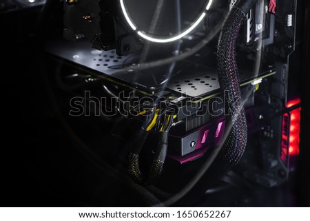 Close-up video card with backlight inside a computer on a black background. The concept of computer games, cyber sports and computer repair. Banner format, wallpapers.