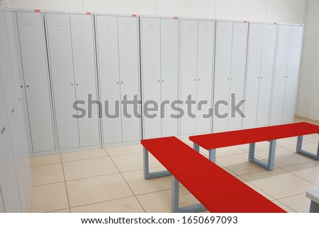 locker room with cupboards and a red bench