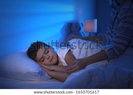 Mother and her little son at home. Bedtime Royalty-Free Stock Photo #1650701617