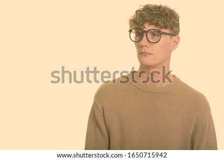 Young handsome nerd man with curly blond hair wearing eyeglasses