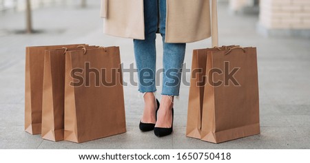 Time for shopping! Cropped photo of woman`s legs and shopping eco bags