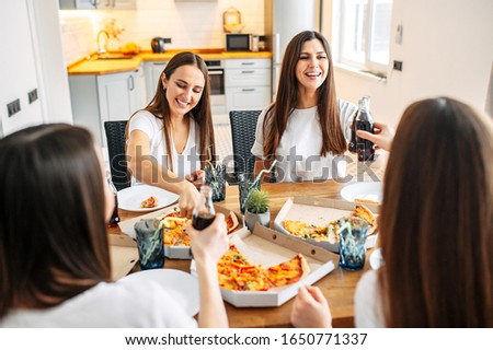 Relax with friends at home. A group of girls have fun together, they eat pizza and laugh.