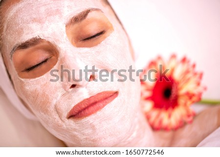 Beauty layer mask for improving the contours of the face and neck applied on the face of a woman