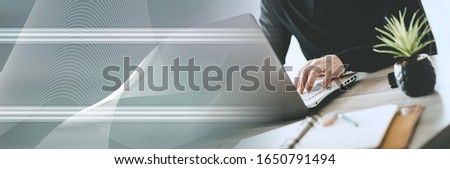 Businessman working on laptop in office; panoramic banner