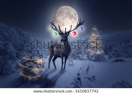 A large deer with Christmas decoration stands outside in the forest.Winter, the moon, and a lot of snow