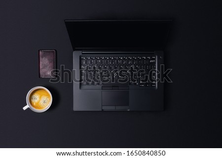 Black desk of work. Workspace on black table with coffee and Wallet.