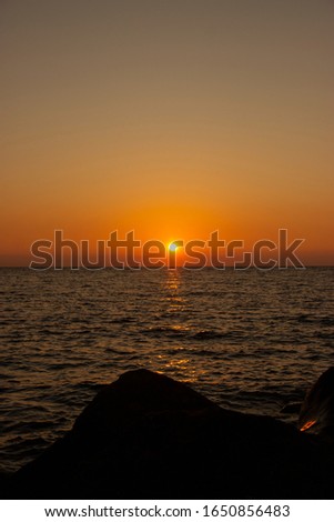 beautiful Sunny sunset on the sea. Amazing summer view on the beach.  blazing sunset landscape at black sea and orange sky above it with awesome sun golden reflection on calm waves.