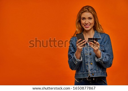 Happy woman with a phone and a card.