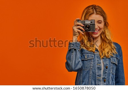 Happy girl takes a photo on old camera.