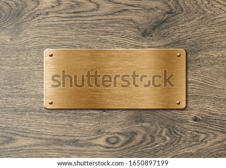 Blank polished golden colored name plate on wooden background to ad text, names or logos Royalty-Free Stock Photo #1650897199