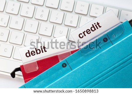 tow hanging folders on in red and in blue on a keyboard having tabs with the words debit and credit on it Royalty-Free Stock Photo #1650898813