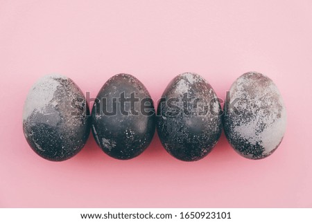 Natural dyed grey and white colored eggs on pastel pink background, top view. Flat lay. Happy Easter. Space for text.