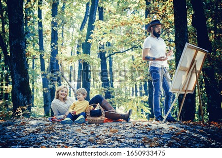 Man artist painting autumn picture. Family camping with kids
