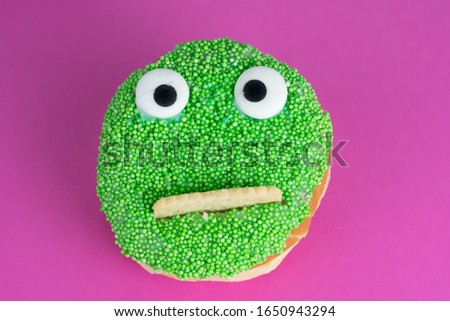 Delicious cake with funny face, pink background