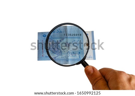 one Malaysia Ringgit and magnifying glass in hand, reverse side