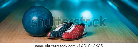 panoramic shot of bowling shoes and ball on skittle alley in bowling club