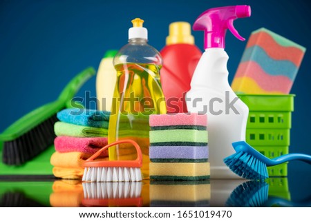 Cleaning concept. Variety of colorful cleaning products on wooden floor.