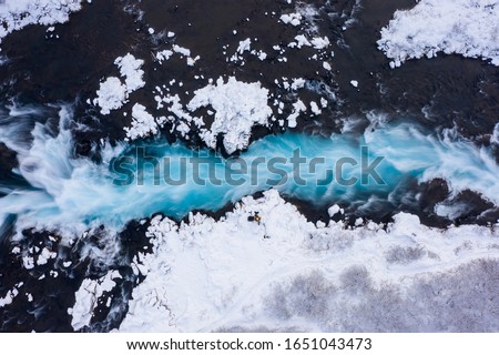 Amazing blue water stream in Iceland in winter. Aerial drone top down view Royalty-Free Stock Photo #1651043473
