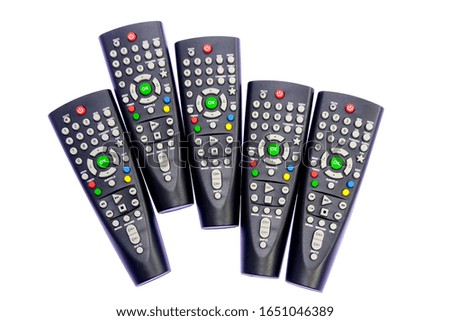five several many pieces black, dark gray TV remote control channel switching, green OK button, on a light, white background with backlight