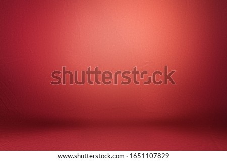 Studio background, backdrop with wall and floor. Light spot on a red fabric background.