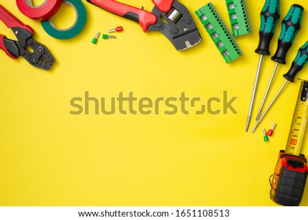 Tools of an electrician-installer or Builder on a yellow background. Building tool