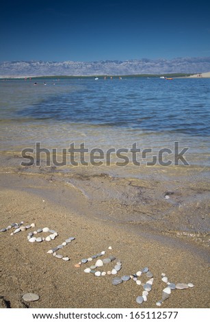 Holiday text made by pebbles, in Croatian beach Nin