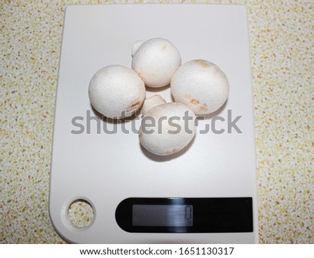 Mushrooms on kitchen scales on the table. Healthy protein nutrition.