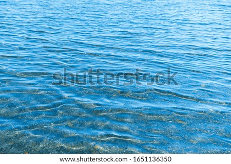 Sea blue water surface with waves near the shore. Background texture.