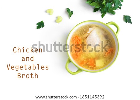 Chicken and vegetables broth or soup isolated on white background, top view, copy space. Homemade healthy meal - cooking fresh chicken or turkey soup.