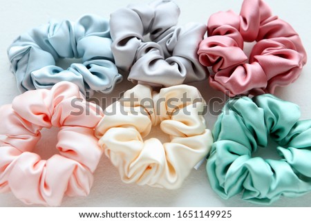 Lot of Colorful silk Scrunchies on white. Flat lay Hairdressing tools and accessories. Hair Scrunchies, Elastic HairBands, Bobble Sports Scrunchie Hairband Royalty-Free Stock Photo #1651149925