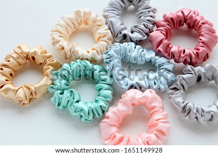 Lot of Colorful silk Scrunchies on white. Flat lay Hairdressing tools and accessories. Hair Scrunchies, Elastic HairBands, Bobble Sports Scrunchie Hairband Royalty-Free Stock Photo #1651149928