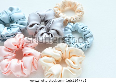 Lot of Colorful silk Scrunchies on white. Flat lay Hairdressing tools and accessories. Hair Scrunchies, Elastic HairBands, Bobble Sports Scrunchie Hairband Royalty-Free Stock Photo #1651149931